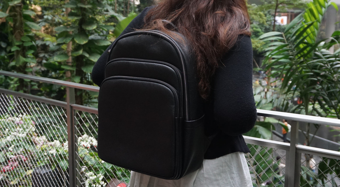 Unisex cowhide leather backpack Crescent design with luggage/trolley sleeve